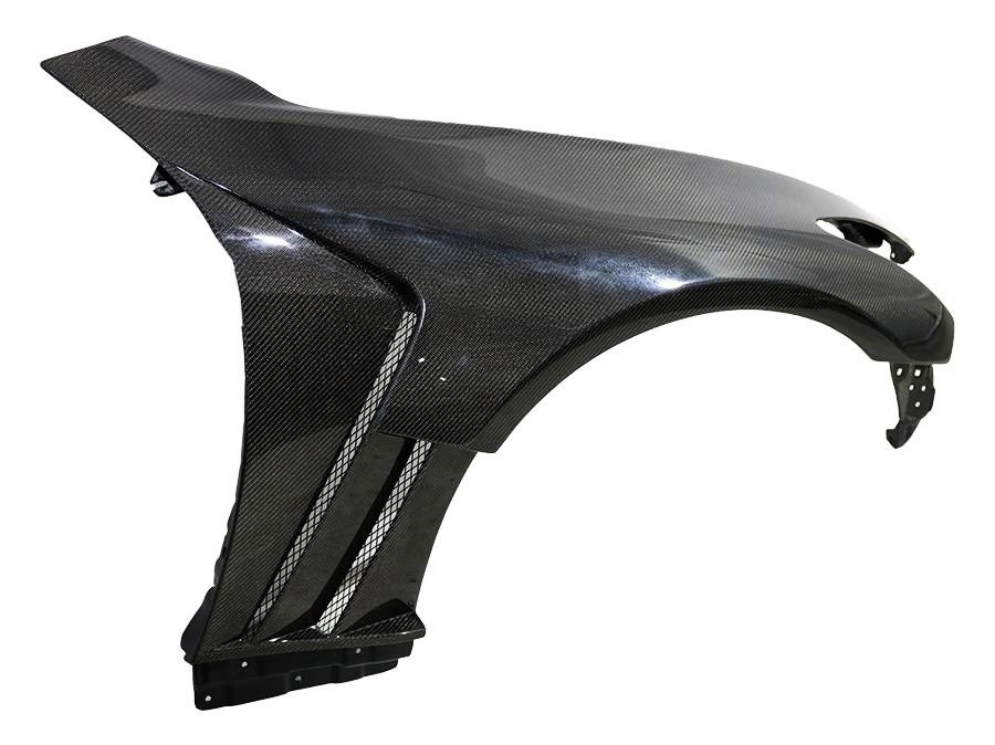 A carbon fiber car fender with a glossy finish and visible weave pattern.