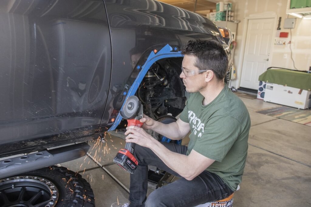 Mechanic using metal snips or a jigsaw to cut the fence