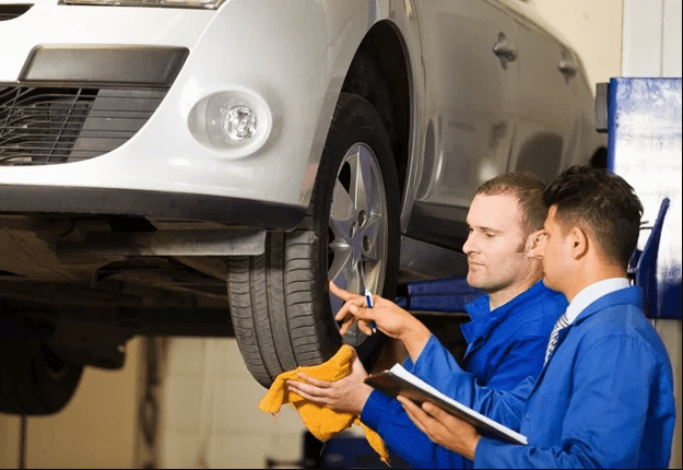  Mechanics checking fender clearance after trimming, a key step in the process of how to trim truck fenders.