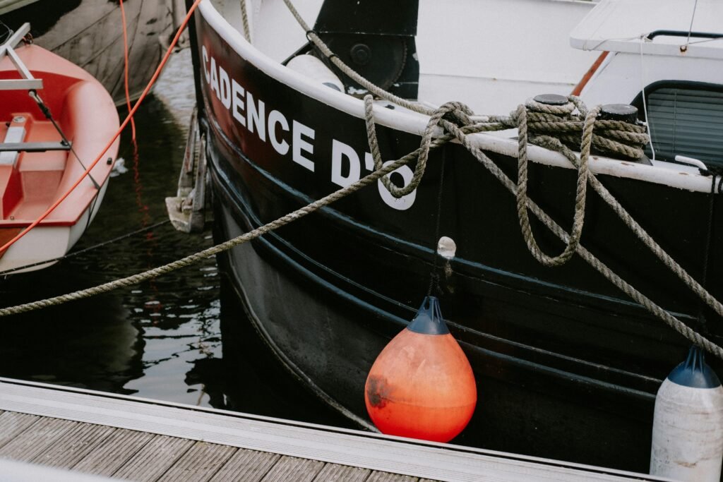 Poorly tied fenders on a blue boat, showing an improper example of how to tie fenders to a boat, with inadequate protection.