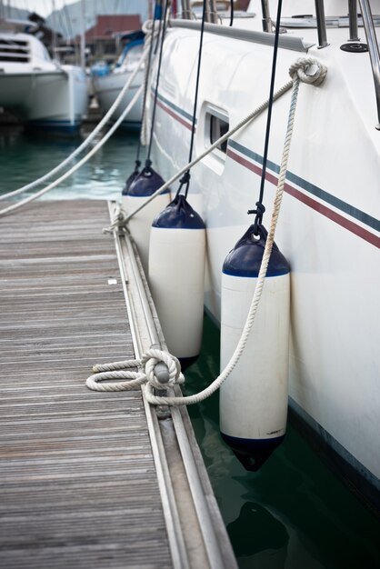 Three boat fenders hanging between the boat and dock 