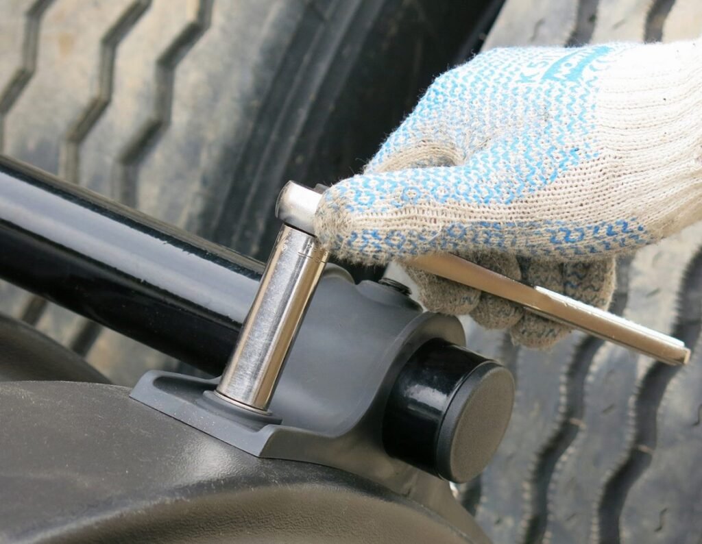 a persone adjusting or tightening the mounting of a quarter fender with a socket wrench