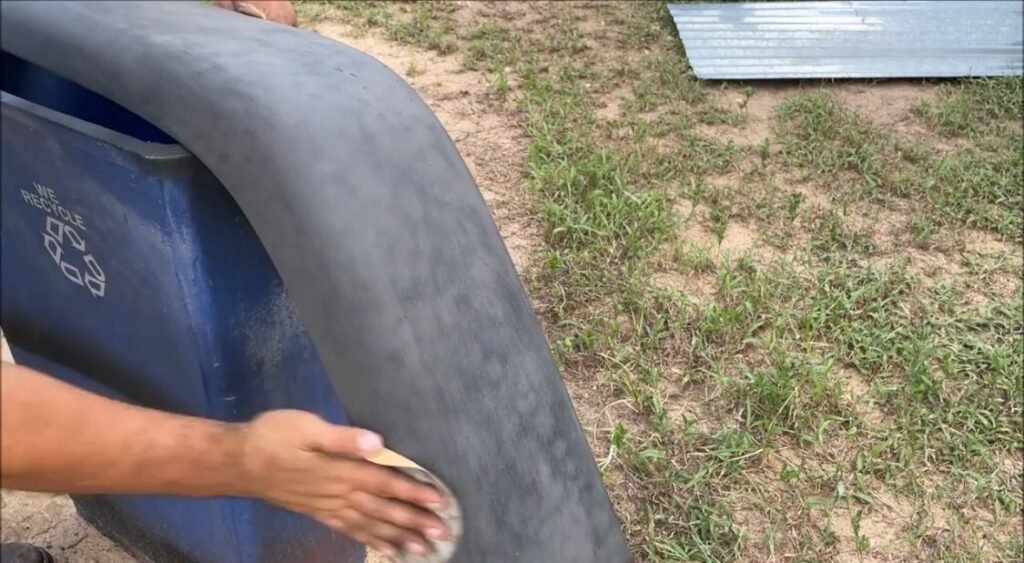 scrubbing the sandpaper to the damaged areas with circular motions.