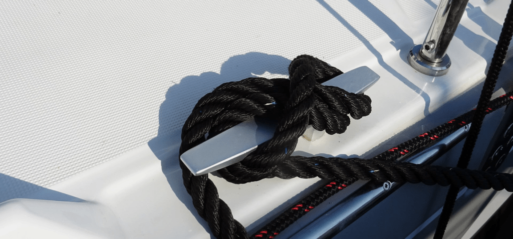 Securing the loop to a cleat to tie rope boat fenders properly.